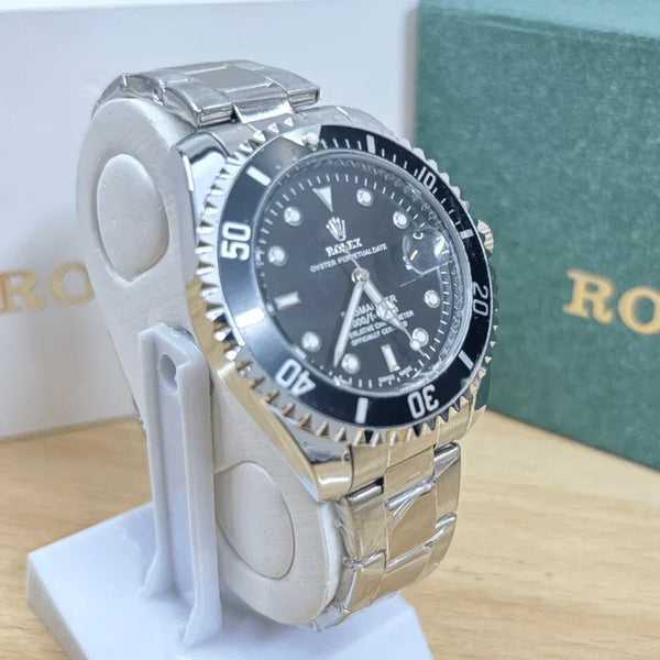 Silver watch with black dial on a white stand, brand name visible