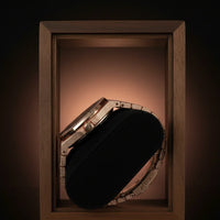 Decorative compact mirror with rhinestone embellishments in a wooden box on a dark background