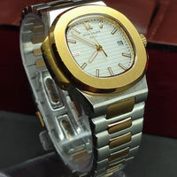 Gold and silver watch with a detailed face on a dark surface