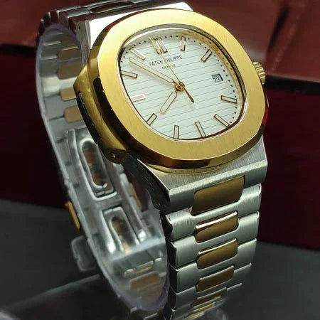 Gold and silver watch with a detailed face on a dark surface