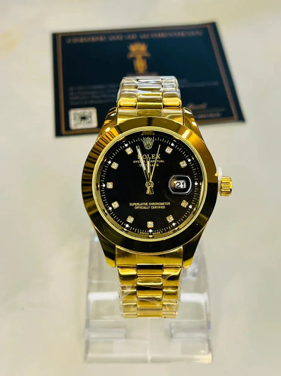 Gold watch with black dial on a stand, with a blurred background