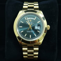 Gold wristwatch on a black cushion against a black background