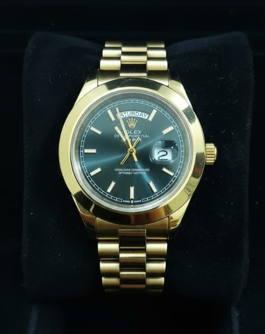 Gold wristwatch on a black cushion against a black background