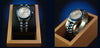Silver watch with blue accents in a wooden display box on a dark background