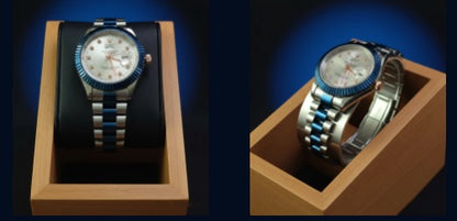 Silver watch with blue accents in a wooden display box on a dark background