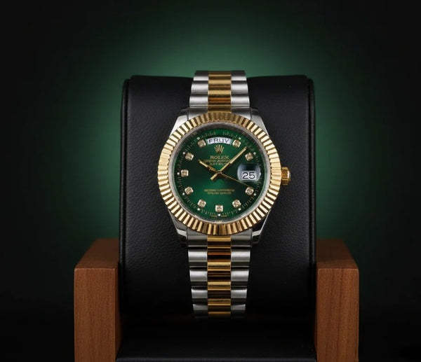 Luxury watch with green dial and gold and silver band on a dark background