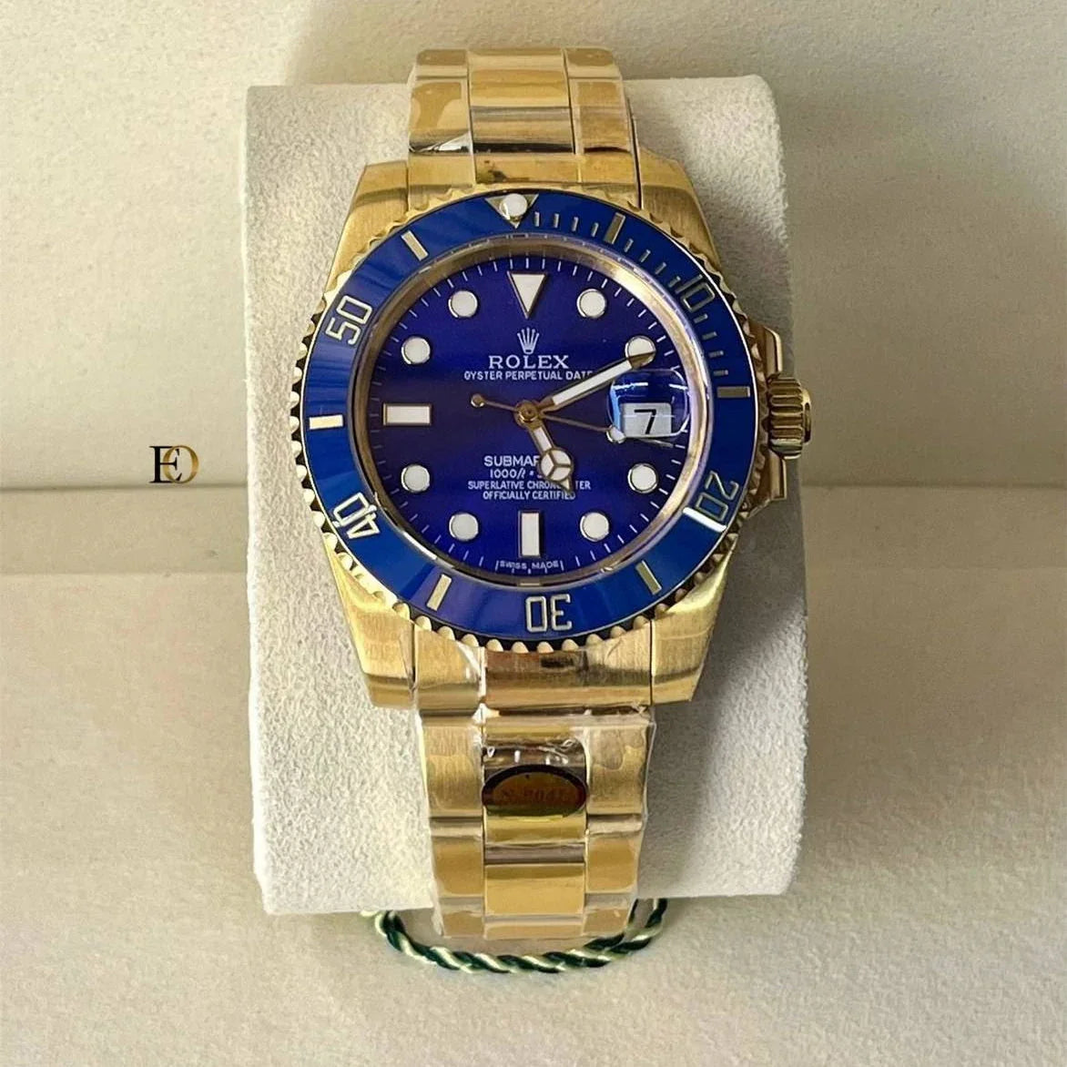 Gold watch with a blue dial on a white stand
