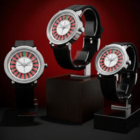 Three watches with unique designs on black stands against a red background