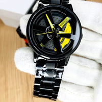 Black and yellow watch with a unique design on a white fabric background