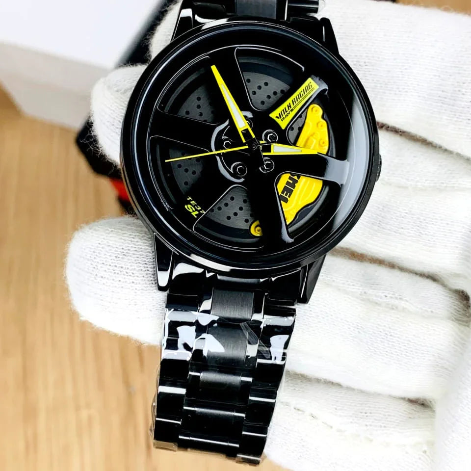 Black and yellow watch with a unique design on a white fabric background